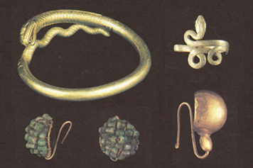 Golden snake bracelet; clustered emerald and gold earrings; silver snake ring; gold earring.